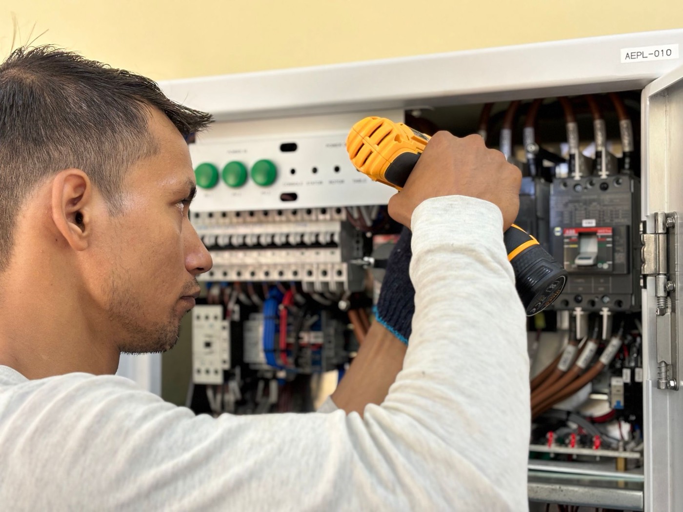 Elettricista al lavoro su un quadro elettrico